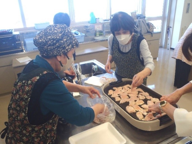 ホットプレートに鶏肉を並べて焼いている様子の写真。