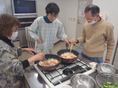 野菜などをを炒め、豚肉と厚揚げの味噌炒めを作っている様子。