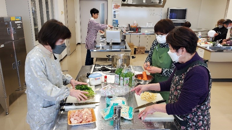 分担して鍋の具材を切っている様子。