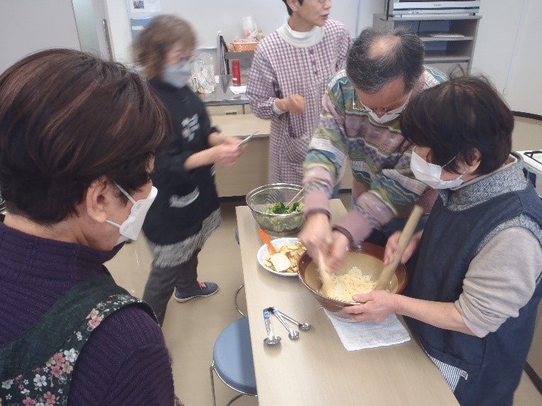 白和えの豆腐をすり鉢ですり、具材を混ぜている様子。