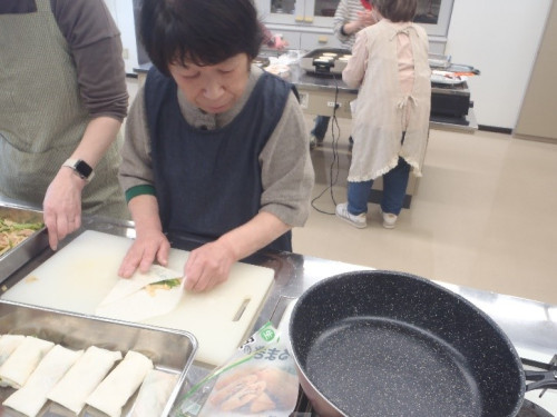 春巻きの皮に具を乗せ、巻いている様子。
