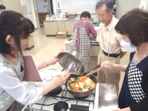 鶏肉と野菜の甘酢炒めの材料をプライパンに入れ炒めている様子。