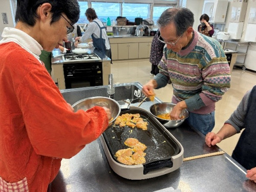 鶏肉に卵をつけ、ホットプレートに並べて焼いている様子。