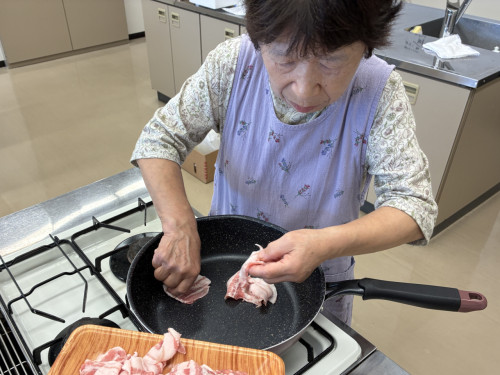 豚肉と茄子のみそ炒めの豚バラ肉をフライパンに広げている様子。