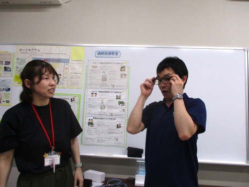 職員が来場者にスマートレンズの説明を行っている様子。