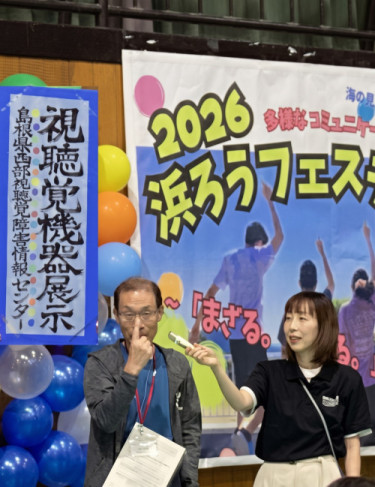 開会式にて、当センター所長が出店ブースの説明を手話で行っている様子。